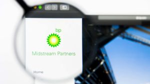 A magnifying glass zooms in on the BP (BP) logo and webpage