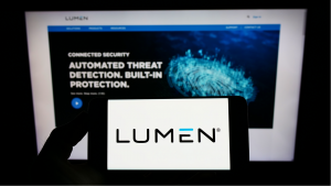 Person holding mobile phone with logo of American telecom company Lumen Technologies Inc. on screen in front of web page