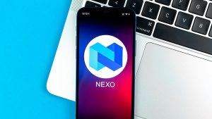 The Nexo logo on an iPhone screen sitting on top of a laptop.