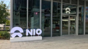 NIO logo and the Nio's user center, NIO House. Retail display of store at downtown LCM mall daytime NIO is a Chinese electric car brand sales person and customers inside. EV stocks