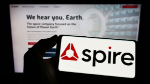 Person holding smartphone with logo of US data analytics company Spire Global Inc. (SPIR) on screen in front of website. Focus on phone display. Unmodified photo.