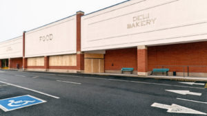 Large supermarket in a shopping center abandoned and boarded up