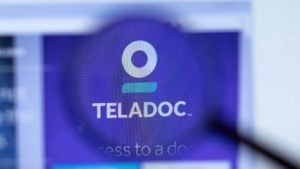 The Teladoc logo through a magnifying glass.