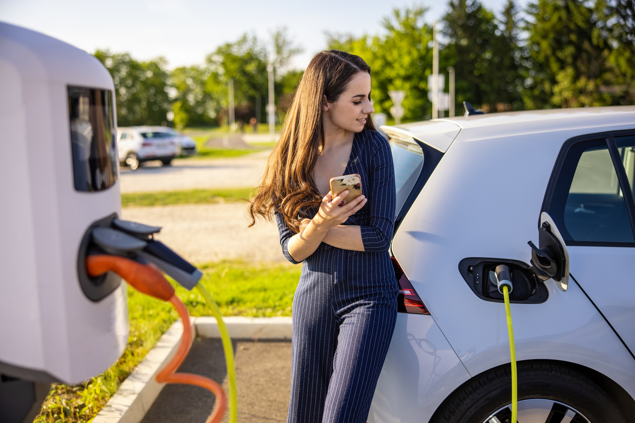 A driver waits for an electric vehicle to charge.