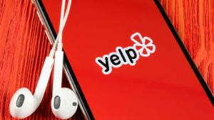 yelp app on a mobile phone with headphones