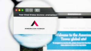 A magnifying glass zooms in on the American Tower (AMT) website.