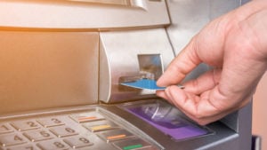bank stocks Hand inserting ATM card into bank machine to withdraw money