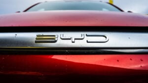 Close-up of BYD (BYDDY) logo on red car, symbolizing BYDDY stock. ev stocks