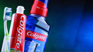 Colgate toothpaste and mouthwash in a cup with a toothbrush