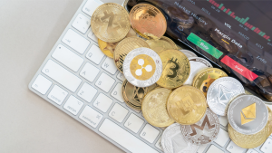 A photo of various crypto coins on a computer keyboard. cryptos to buy