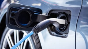 Photo of charging port on electric vehicle (EV) plugged into and being charged. EV Charging Stocks