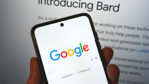Google launches Bard AI. Google search bar on a phone in hand with release information on background. Google Bard AI vs OpenAI ChatGPT. . reliable blue-chip stocks