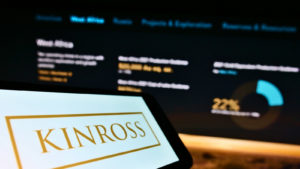 Cellphone with business logo of Canadian mining company Kinross Gold Corp. on screen in front of webpage.