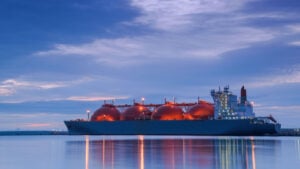 Large tanker ship carrying natural gas at dusk in harbor