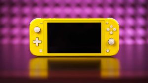 A yellow Switch Lite from Nintendo (NTDOY) sits in front of a bright pink background.