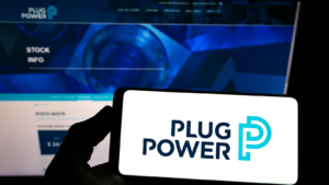 Person holding smartphone with logo of US hydrogen fuel cell company Plug Power Inc. on screen in front of website. Focus on phone display. Unmodified photo. PLUG stock