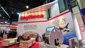 A booth showcasing various technologies offered by Raytheon.