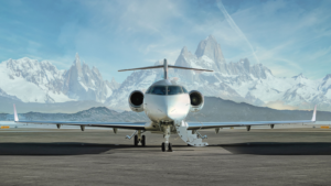 Private jet waiting to be boarded on runway with snowy mountains in the background. UP stock