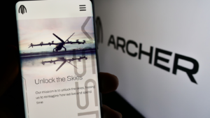 Person holding mobile phone with web page of US eVTOL aircraft company Archer Aviation Inc. (ACHR) on screen with logo. Focus on center of phone display. Unmodified photo. Archer Aviation Stock Analysis
