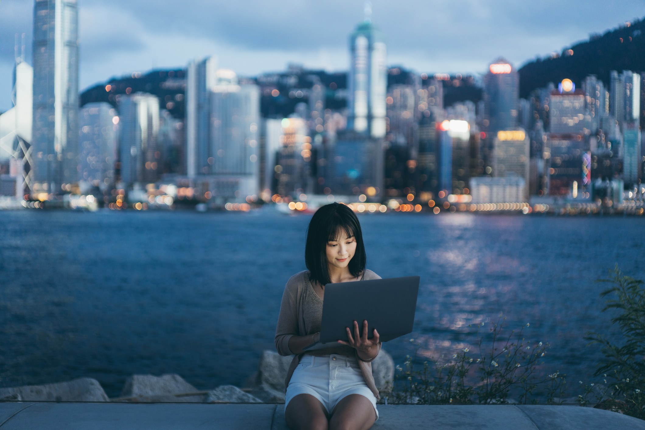 A woman on her laptop with a skyline in the background