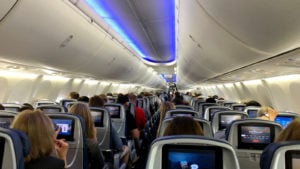 Delta airlines aircraft interior full of passengers. Why are so many flights overbooked?