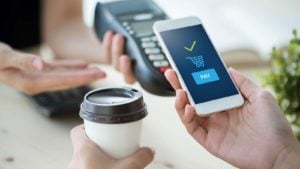 A concept image of mobile payment with a smart phone for a cup of coffee.