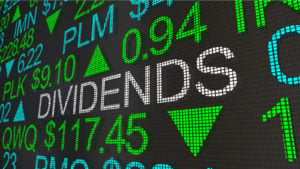 stock market ticker screen with the word "dividends" appearing in large text. Must-Have Dividend Stocks. Dividend kings to own