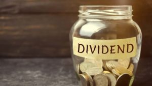 Glass jar of coins marked "dividends" to represent dividend stocks. dividend stocks for passive income