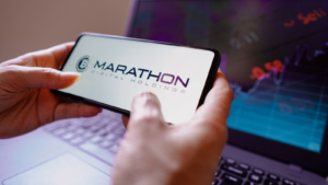 In this photo illustration, the Marathon Digital Holdings (MARA) logo seen displayed on a smartphone screen