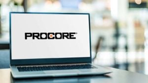 A laptop displays the logo for Procore Technologies (PCOR).