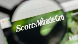 Scotts Miracle-Gro logo displayed on a web browser and magnified by a magnifying glass
