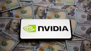 Nvidia logo seen on smartphone which is placed on pile of US dollar bills. Concept. Selective focus. Stocks to buy like Nvidia