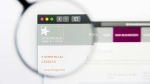 An image of an web page with a magnifying glass zoomed in on the top left of the screen showing red, yellow, and green circle buttons, a left and right arrow button, a third button, and the white box star logo for Starwood Property Trust.