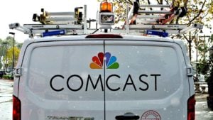 Image of the Comcast (CMCSA) logo on the back of a white van in a rural area