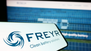 Mobile phone with logo of Norwegian battery company Freyr AS (FREY) on screen in front of business website. Focus on left of phone display. Unmodified photo.