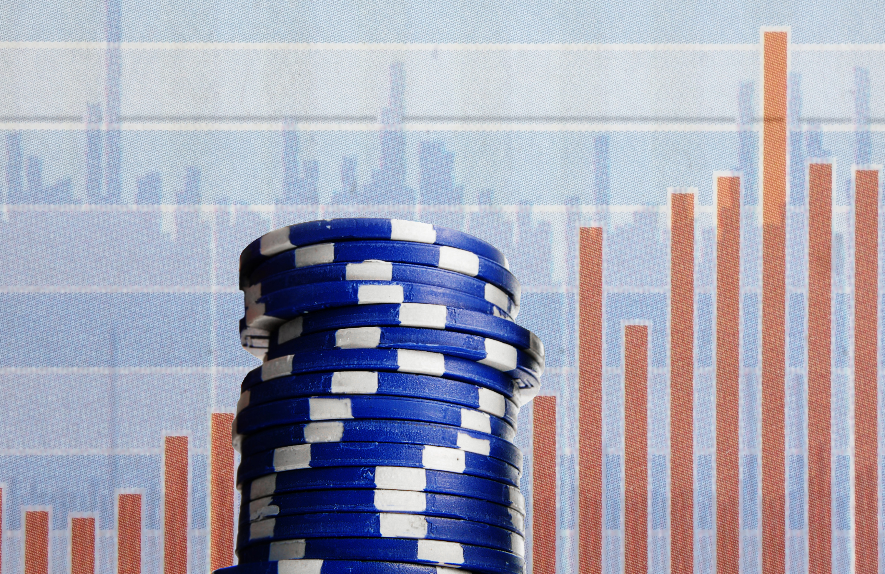 Blue poker chips in front of a stock chart.