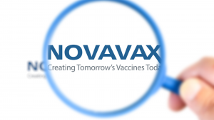 Novavax (NVAX) research laboratory logotype enlarged with a magnifying glass.This laboratory has developed a vaccine against the covid-19 virus. NVAX price predictions.