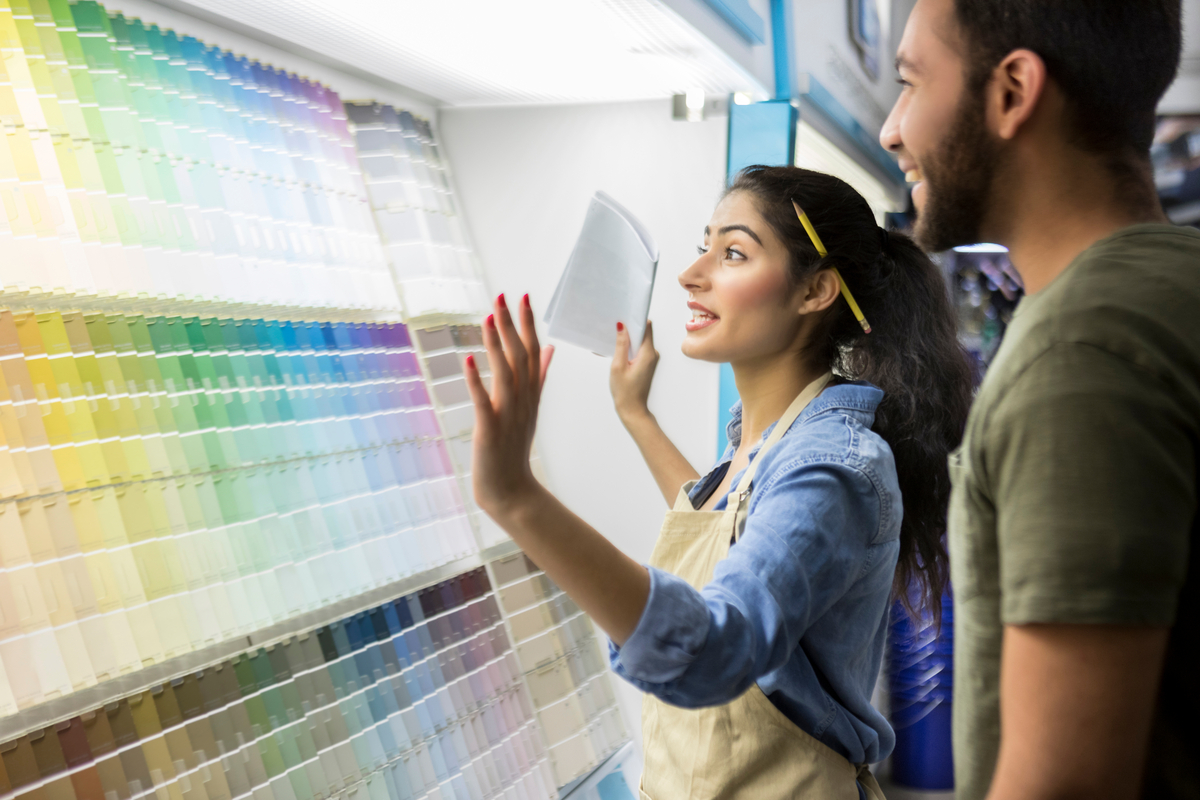 A worker smiles while going over color palettes with a customer.