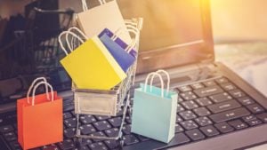 e-commerce stocks, Image of small shopping bags sitting in a shopping cart on a computer. Strong Buy E-Commerce Stocks