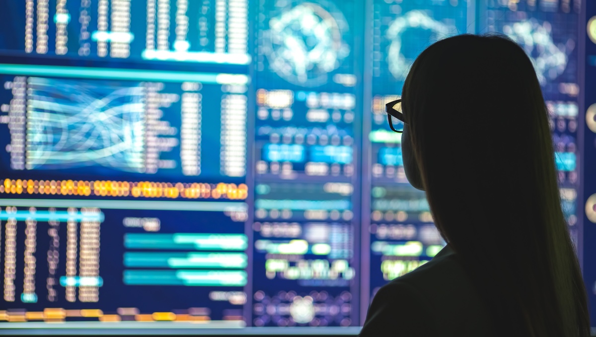 A person looking at a chart with screens.
