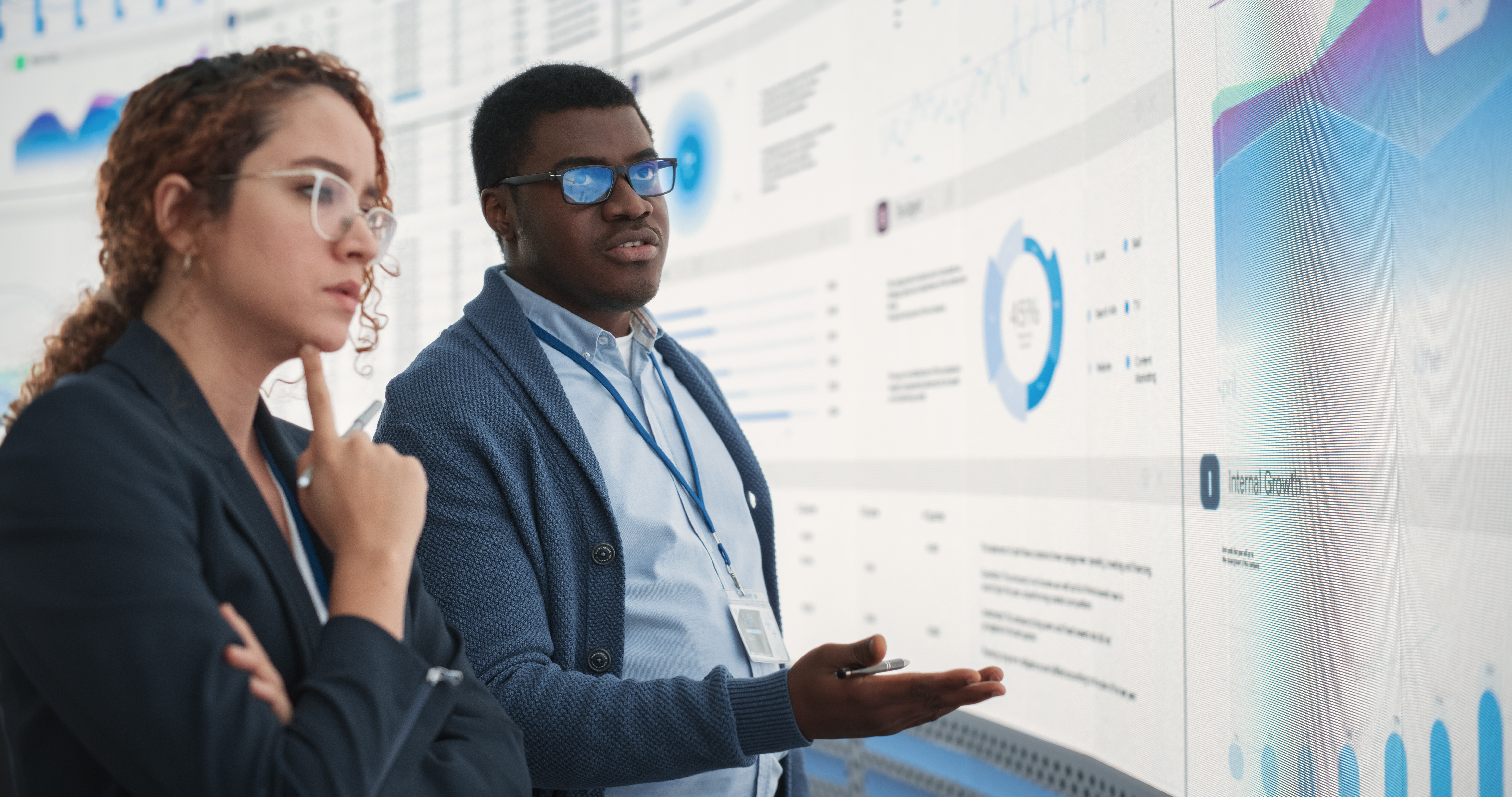 Data analysts looking at data on a big screen.