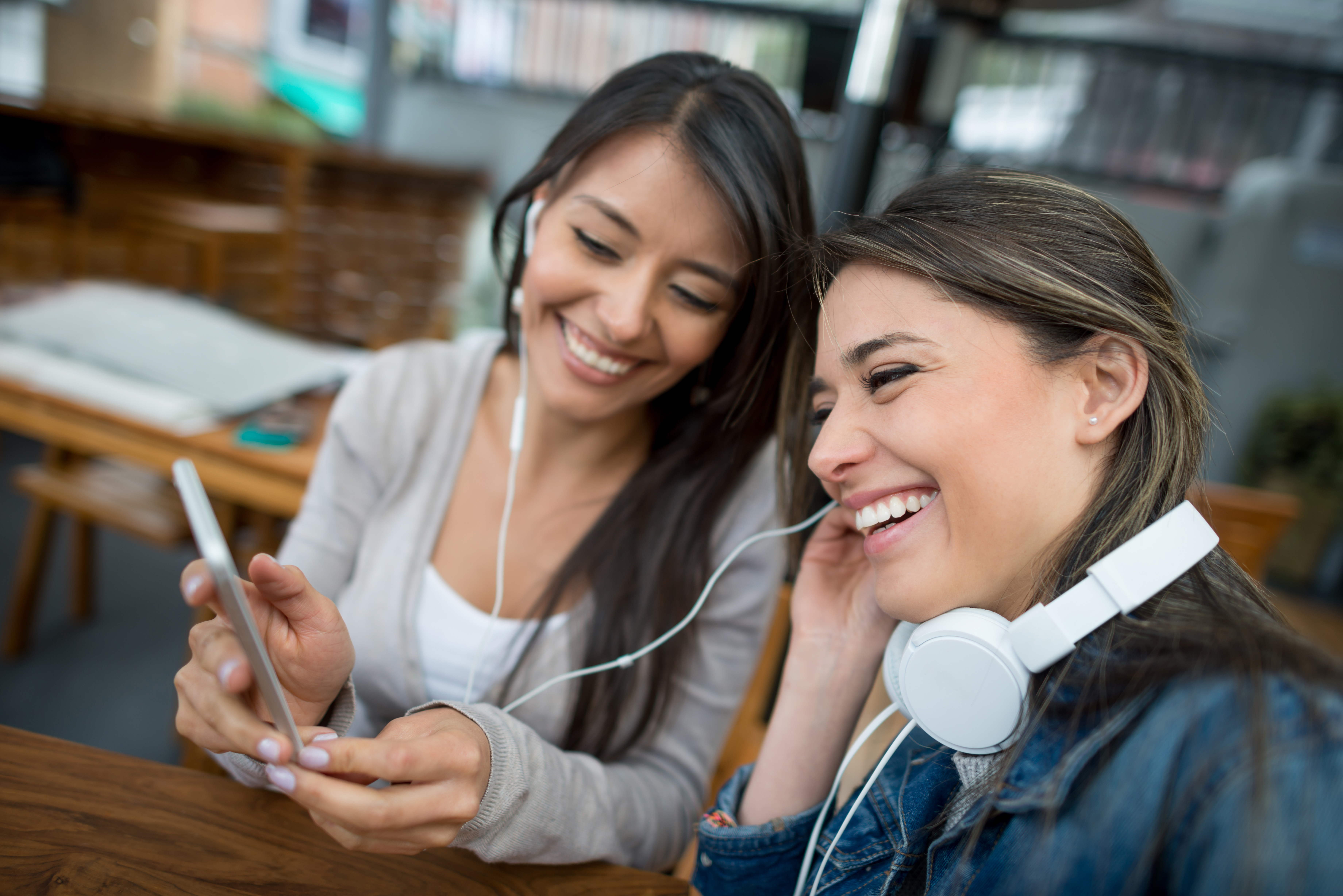 Two people smiling, looking at phone.